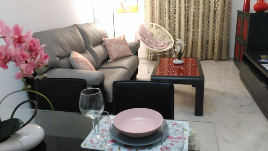 sala de estar con sofá y mesa en Apartamento Los conquistadores., en Sanlúcar de Barrameda