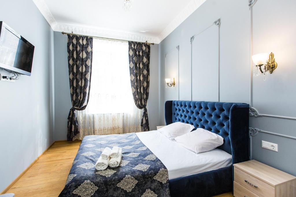 ein Schlafzimmer mit einem blauen Bett und einem Fenster in der Unterkunft Дизайнерська ВІП квартира по вулиці Куліша 14 in Lwiw