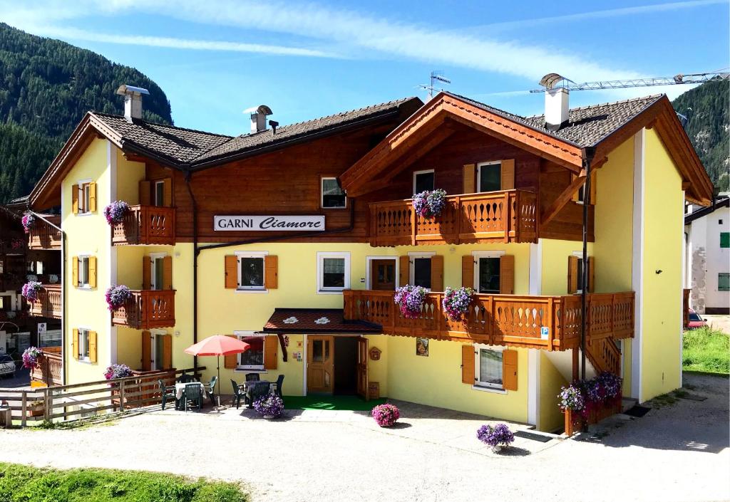 - un grand bâtiment en bois avec un balcon dans l'établissement Garni Ciamorc, à Canazei