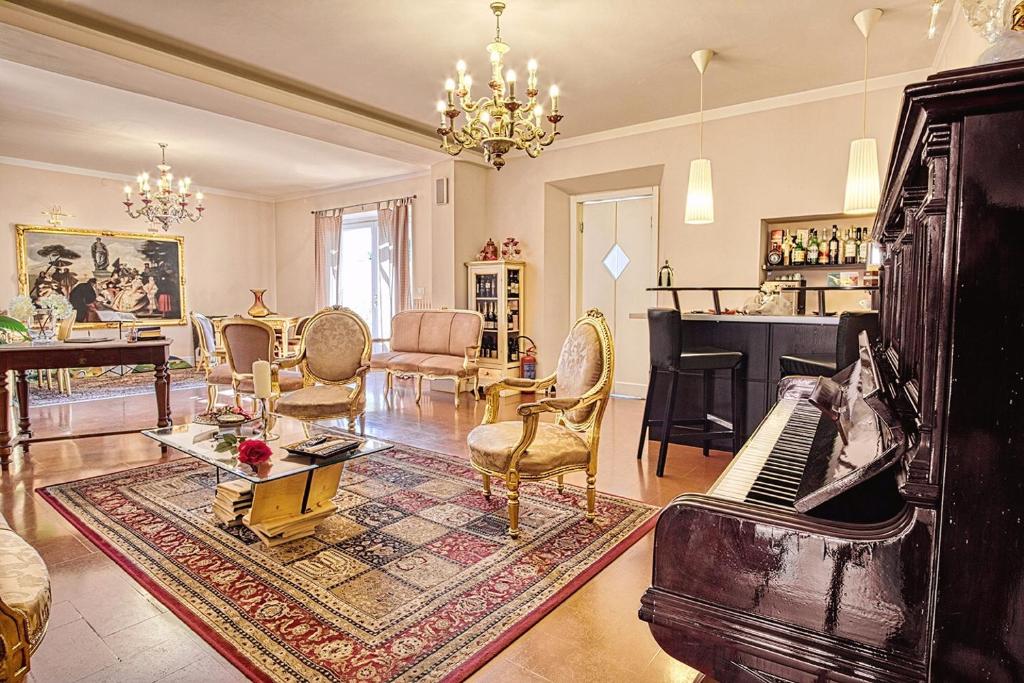 un soggiorno con pianoforte e un soggiorno con sedie di Boutique Hotel L'Imperatrice a Foiano della Chiana