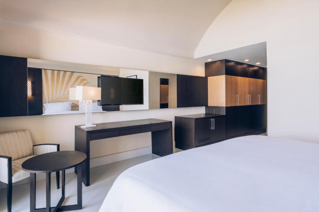 a hotel room with a bed and a desk and a tv at Iberostar Selection Kuriat Palace in Monastir