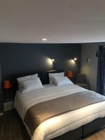 ein Schlafzimmer mit einem großen Bett mit zwei Kissen in der Unterkunft HOTEL HOVI DE LA MAIRIE in Aubervilliers