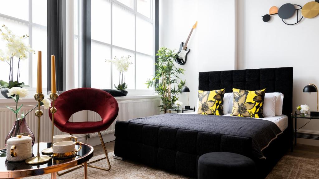una camera con un letto nero e una sedia rossa di PHENOMENAL 5bedroom DESIGN HOUSE FOR NOMADS XXL GROUPS a Londra