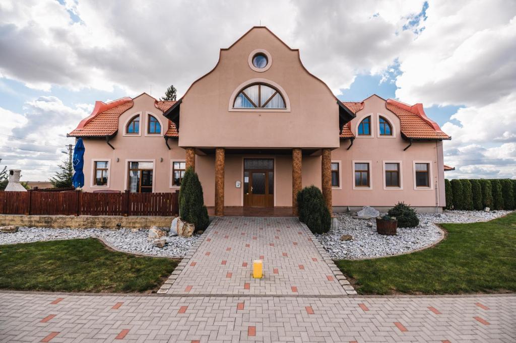 a large house with a driveway in front of it at Motel ARD in Sarovce