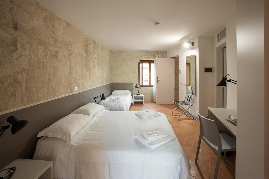 una camera con 2 letti e una scrivania di Ostello del Castello di Santa Severa a Santa Severa