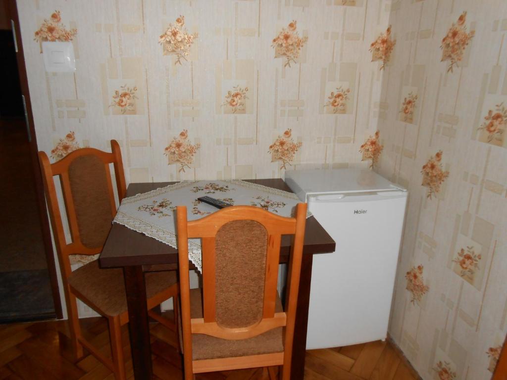 uma cozinha com uma mesa e cadeiras e um frigorífico em Hostel Noclegi Chorzow em Chorzów