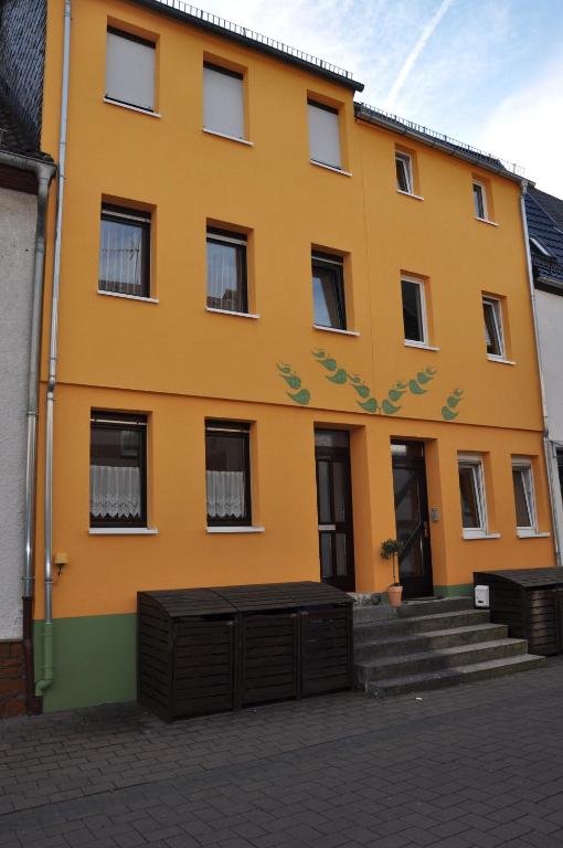 un edificio amarillo con escaleras delante en FEWO Haus Meister en Hadamar