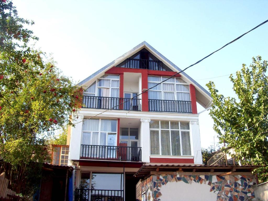 提比里斯的住宿－Hotel NADIKVARI，带阳台的红白色房屋