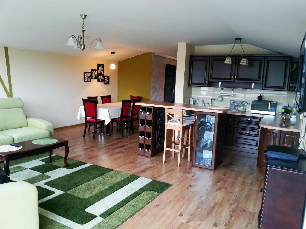 uma cozinha e sala de estar com um sofá e uma mesa em Apartament Kleopatra em Limanowa