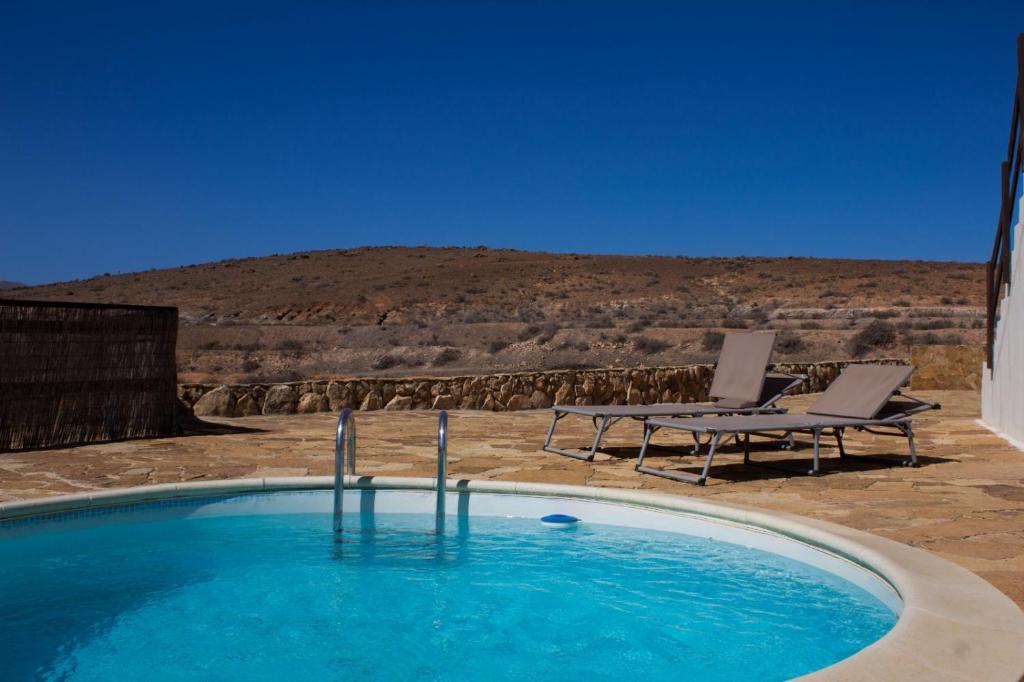 a swimming pool with chairs and a view of the desert at Casa El Horno in Antigua