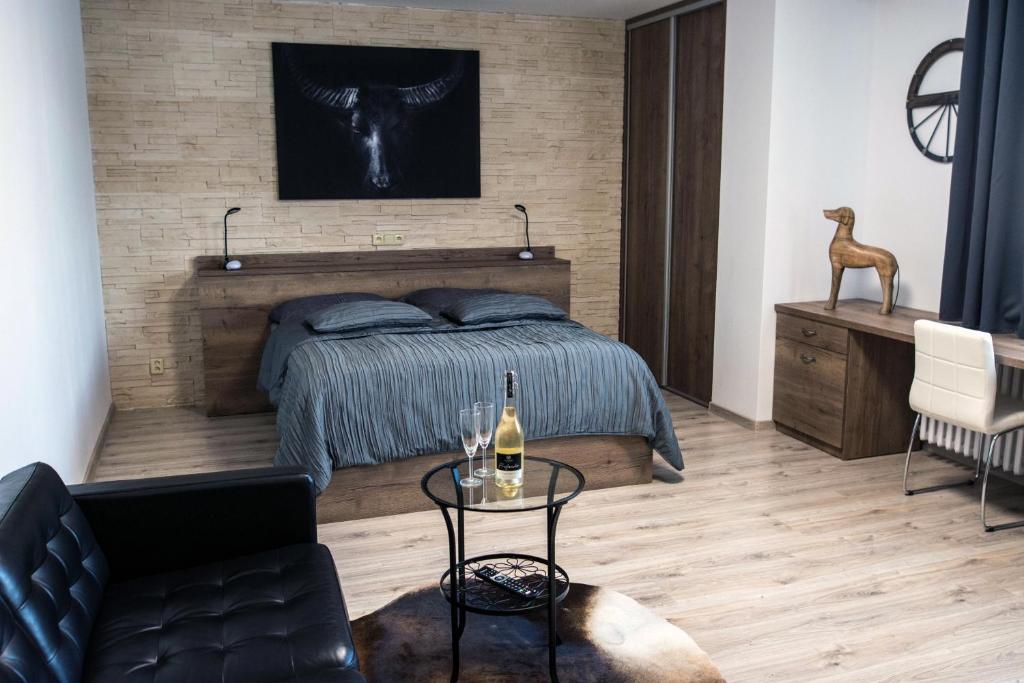 um quarto com uma cama e uma mesa com uma garrafa de vinho em Ubytování Stračena em Ostrava