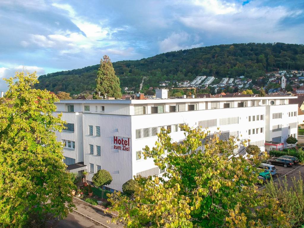 ZUM ZIEL Hotel Grenzach-Wyhlen bei Basel في غرنزاش ويلن: مبنى أبيض عليه شجرة
