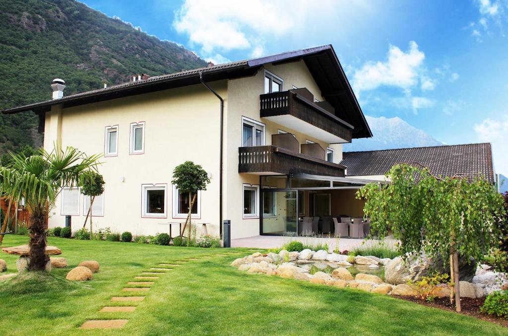 a white house with a grass yard at Pension Nadine in Naturno