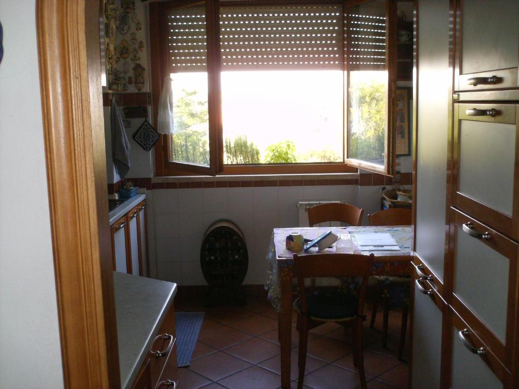 una pequeña cocina con mesa y ventana en Talenti house, en Roma