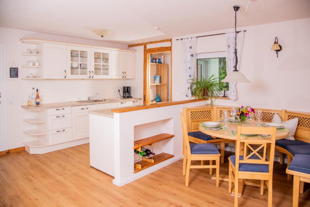 cocina y comedor con mesa y sillas en Ferienhof Moosing, en Amtzell