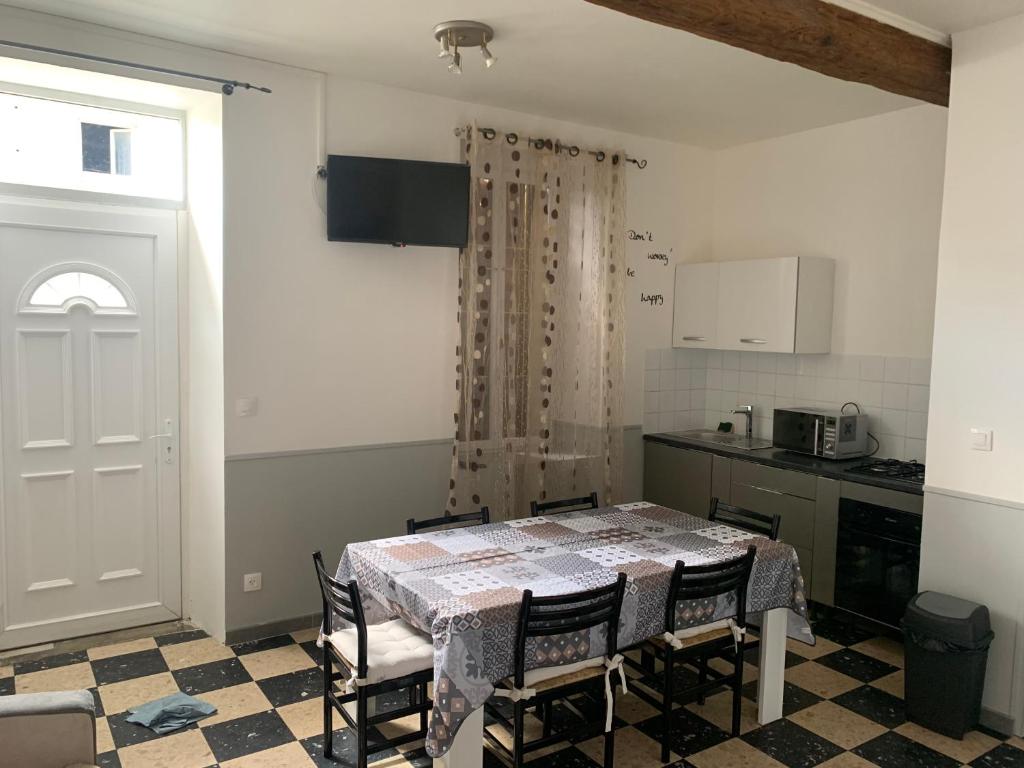 a kitchen with a table and chairs and a kitchen with a window at maison des corbieres in Conilhac-Corbières