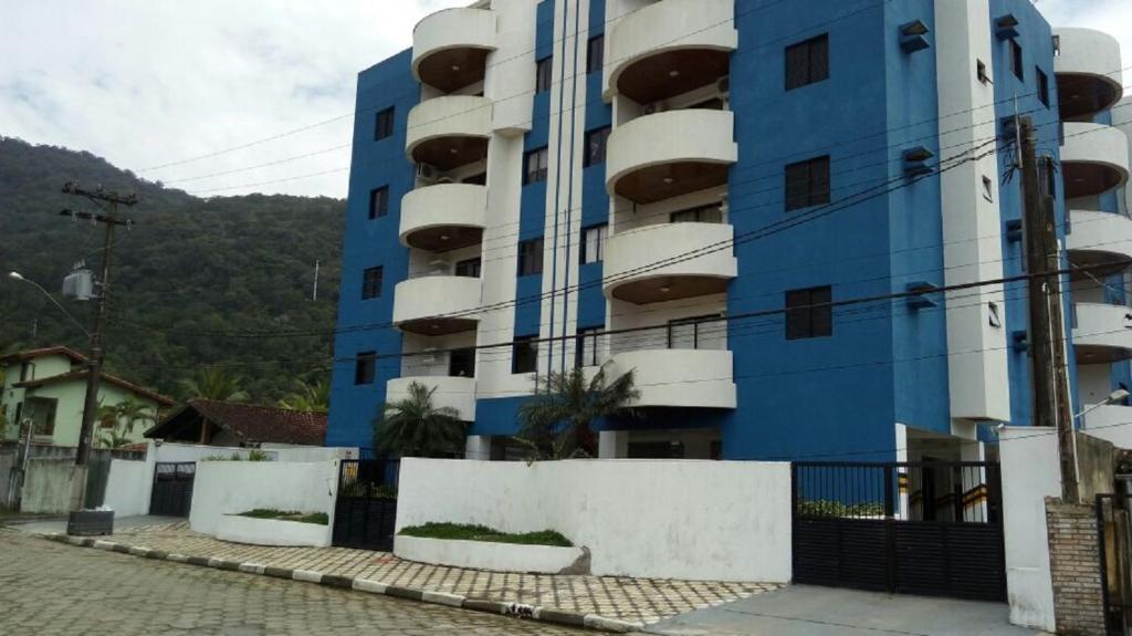 a blue apartment building with a fence in front of it at Apto Ubatuba - Toninhas in Ubatuba