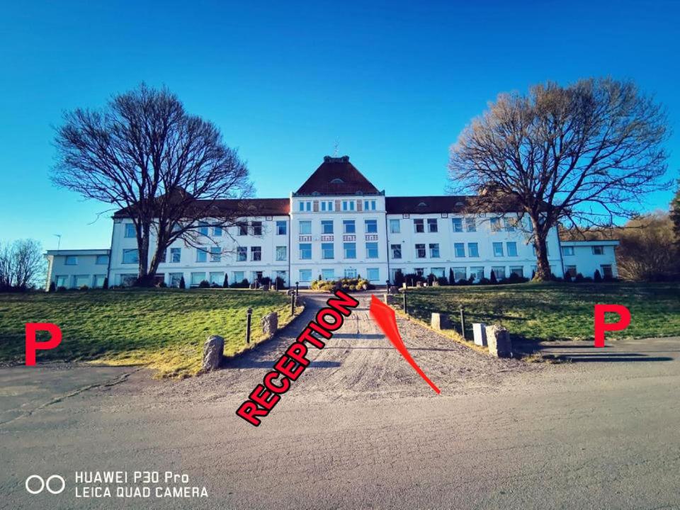 a large white building with a red arrow in front of it at Liahof in Ullared