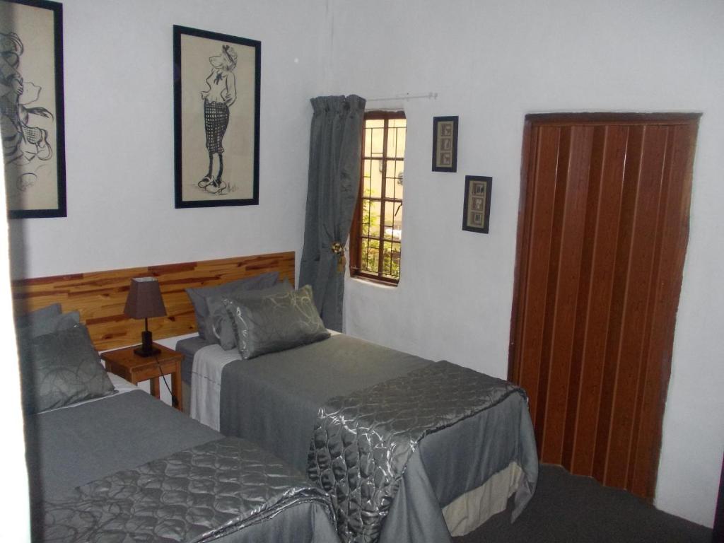 una camera con due letti e una porta con finestra di Villa Ocean Crest B&B a Gansbaai