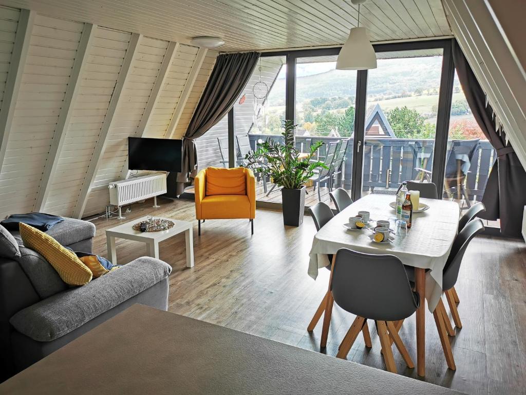 een woonkamer met een tafel en stoelen bij Ferienhaus in der Rhön Sitzmann in Bischofsheim an der Rhön