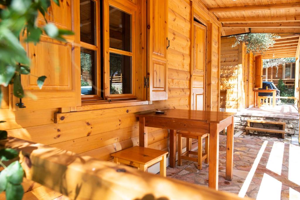 a wooden cabin with a wooden table and benches at Nashos Bungalows in (( Spile ))