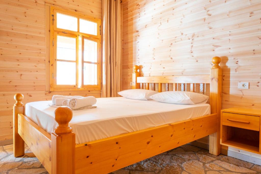 a bedroom with a bed in a log cabin at Nashos Bungalows in (( Spile ))