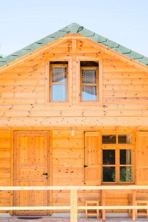 a wooden cabin with windows and a pitched roof at Nashos Bungalows in (( Spile ))
