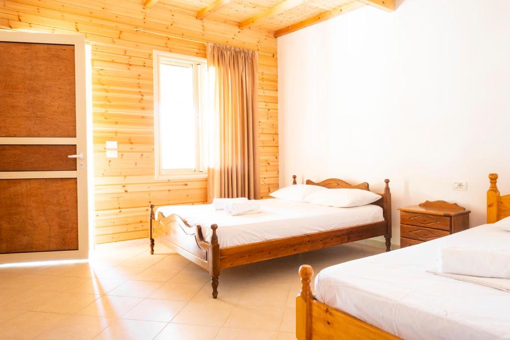 a bedroom with two beds and a window at Nashos Bungalows in (( Spile ))