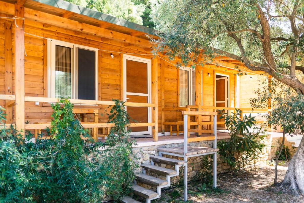 a log cabin with stairs leading to the front porch at Nashos Bungalows in (( Spile ))