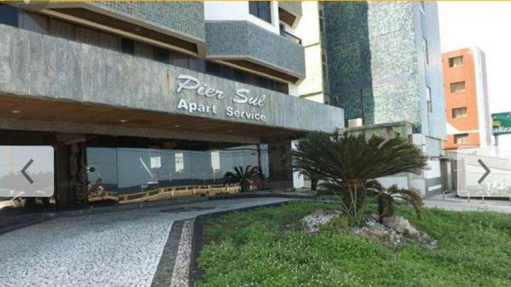 a building with a sign that reads pizza six agent square at Apartamento Velozo Santos in Salvador