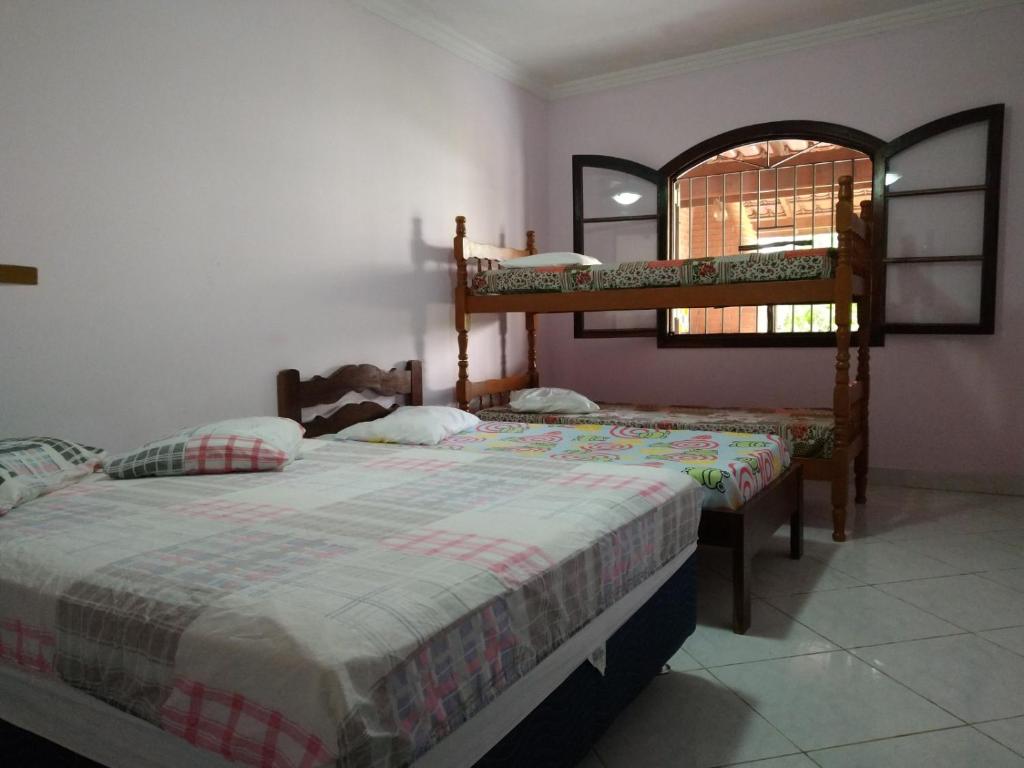 a bedroom with two bunk beds and a mirror at Casa do Jaco in Caraguatatuba
