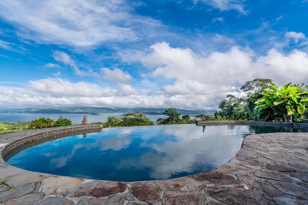 a large pool of water in front of a stone wall at Nepenthe B&B in El Castillo de La Fortuna