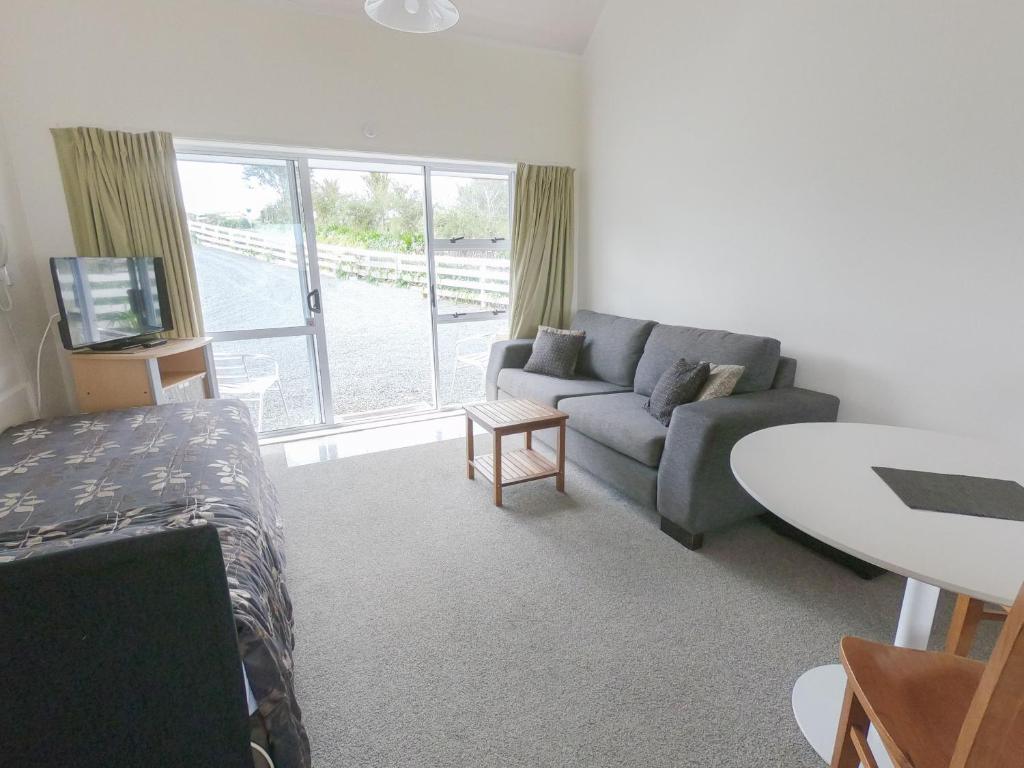 a living room with a couch and a table at Castle Court Motel in Wellsford