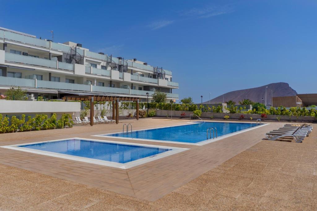 a swimming pool in front of a building at TEJITA BEACH APARTMENT in El Médano