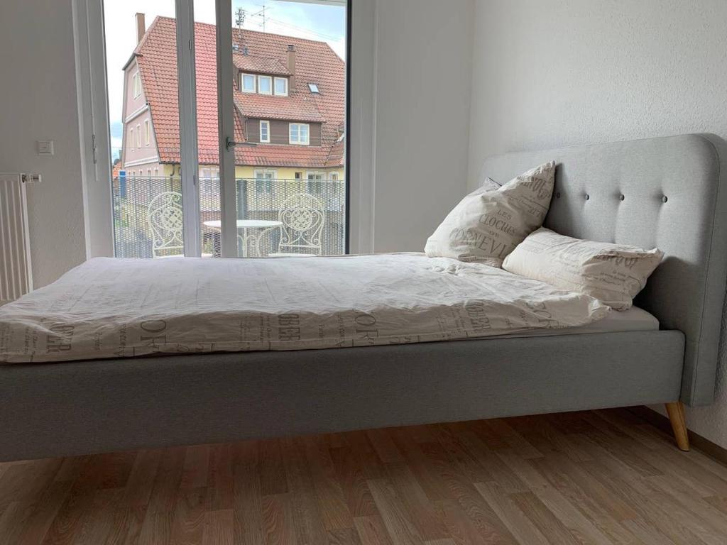 Bett in einem Zimmer mit einem großen Fenster in der Unterkunft 1-Zi. Apartment, Echterdingen bei Flughafen/Messe Stgt. in Leinfelden-Echterdingen