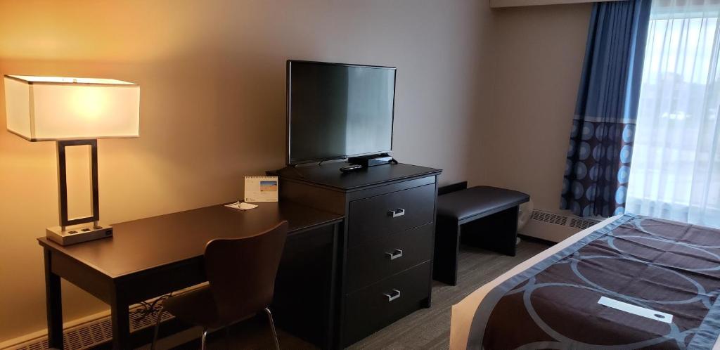 a hotel room with a bed and a television on a dresser at Super 8 by Wyndham Spruce Grove in Spruce Grove