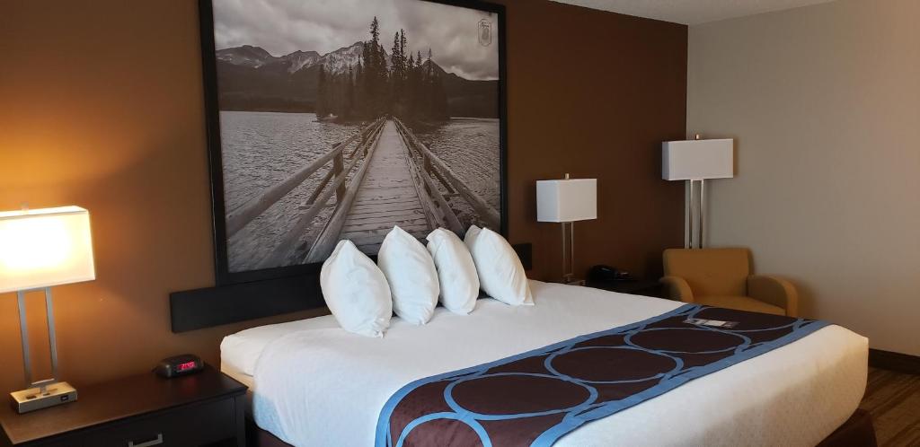 a hotel room with a bed with a picture on the wall at Super 8 by Wyndham Spruce Grove in Spruce Grove