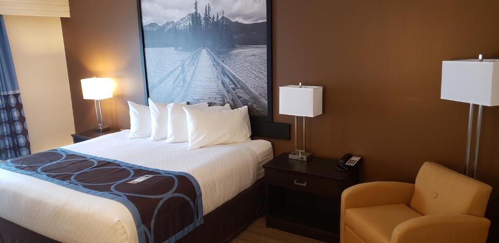 a hotel room with a bed and a chair at Super 8 by Wyndham Spruce Grove in Spruce Grove