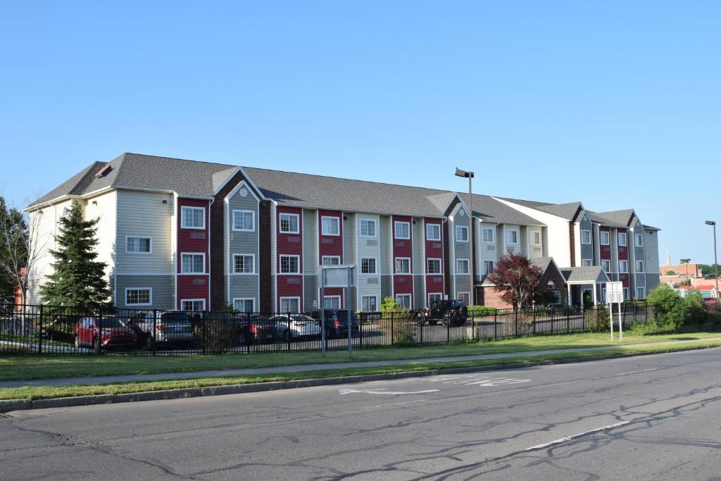 un gran edificio de apartamentos con ventanas rojas y blancas en Inn at the Finger Lakes, en Auburn