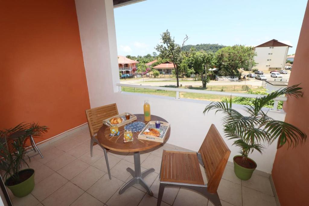 Un balcón con una mesa con comida. en Le Studio Laetitia, en Cayenne