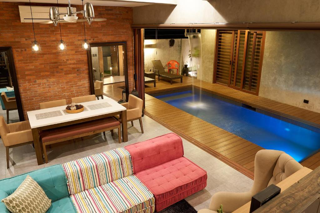 una sala de estar con una piscina en el centro en ISLA VILLA 1 amazing waterfall pool house near beach, bars & restaurants, en Mactan