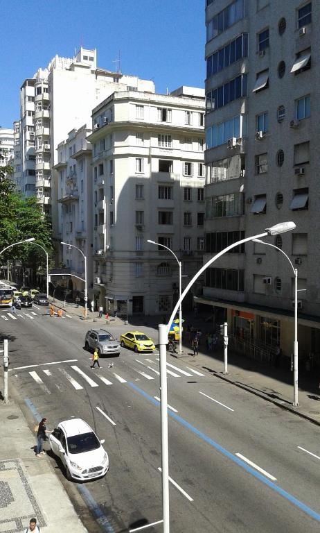 una calle de la ciudad con coches en la carretera y edificios en Copacabana uma quadra da praia, en Río de Janeiro