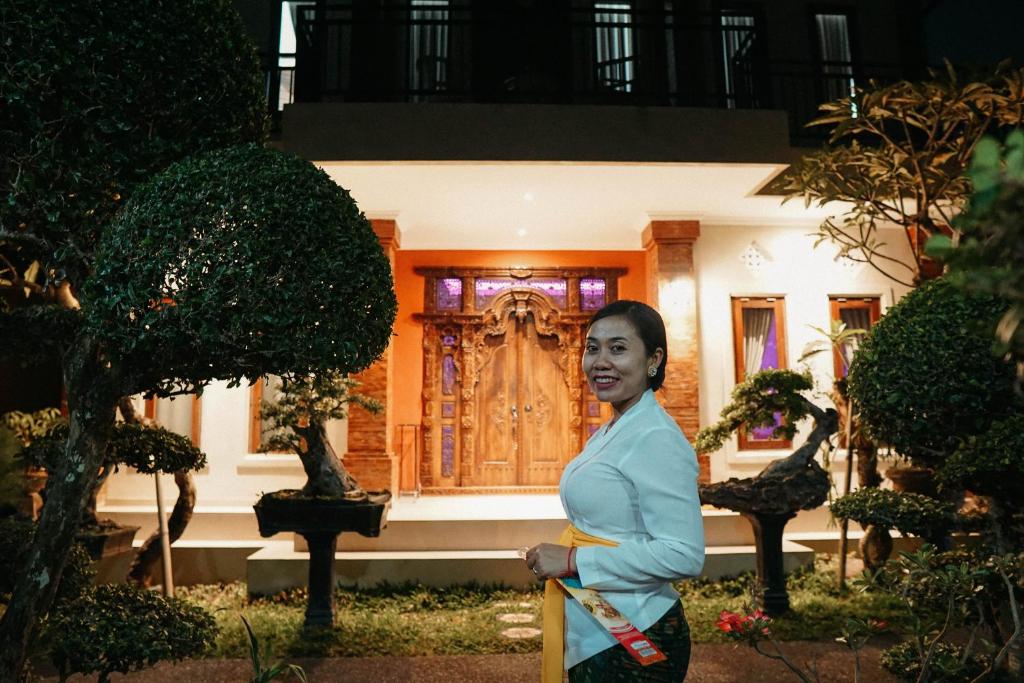 uma mulher em pé em frente a uma casa em HOKYY Accommodation em Ubud