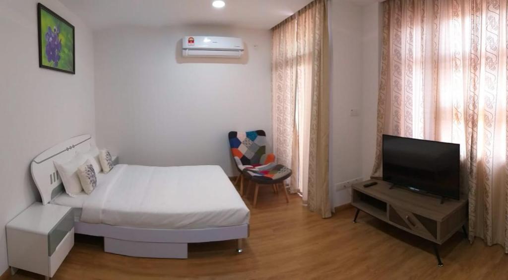 a bedroom with a bed and a television in it at Coconut Bay Lodge in Bandar Seri Begawan