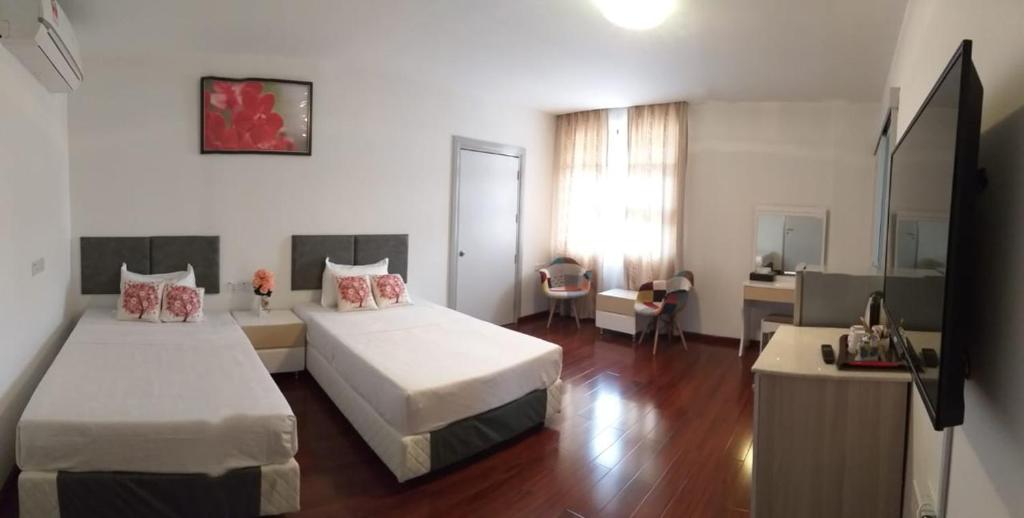 a hotel room with two beds and a desk at Coconut Bay Lodge in Bandar Seri Begawan