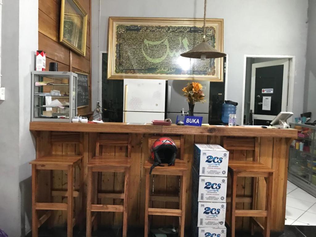 a kitchen with a wooden bar with stools at The Carstensz Homestay in Manda