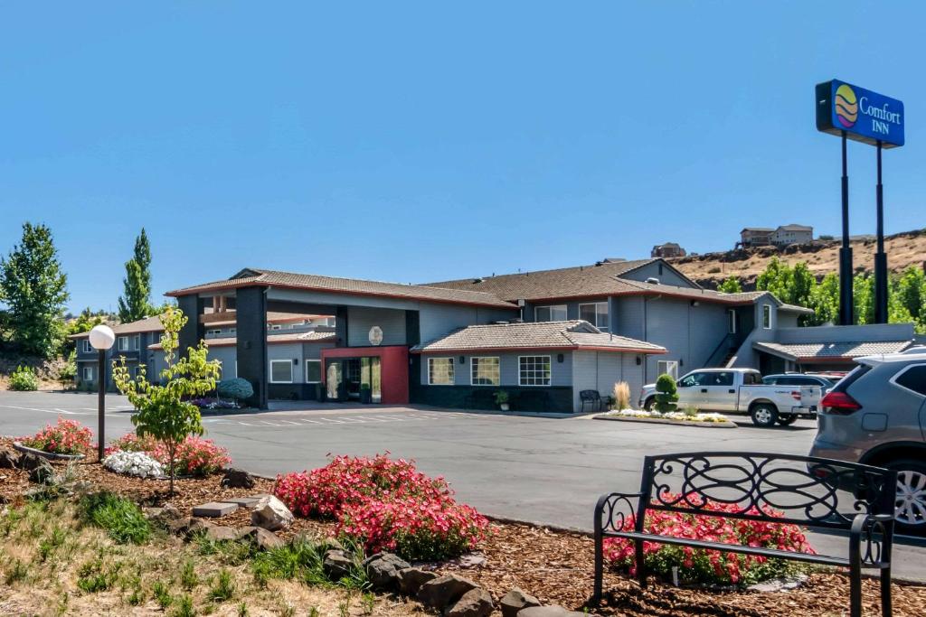 un hotel con un banco frente a un aparcamiento en Comfort Inn Columbia Gorge, en The Dalles