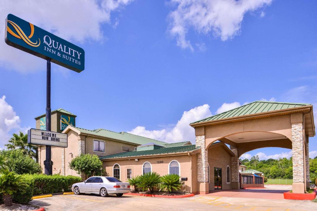 un coche aparcado frente a un edificio con una señal en Quality Inn and Suites Beaumont, en Beaumont