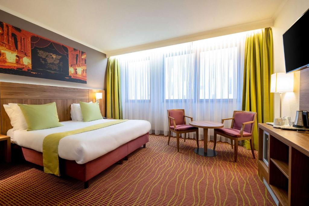 une chambre d'hôtel avec un lit, une table et des chaises dans l'établissement Hotel Opera Antwerpen Centrum, à Anvers