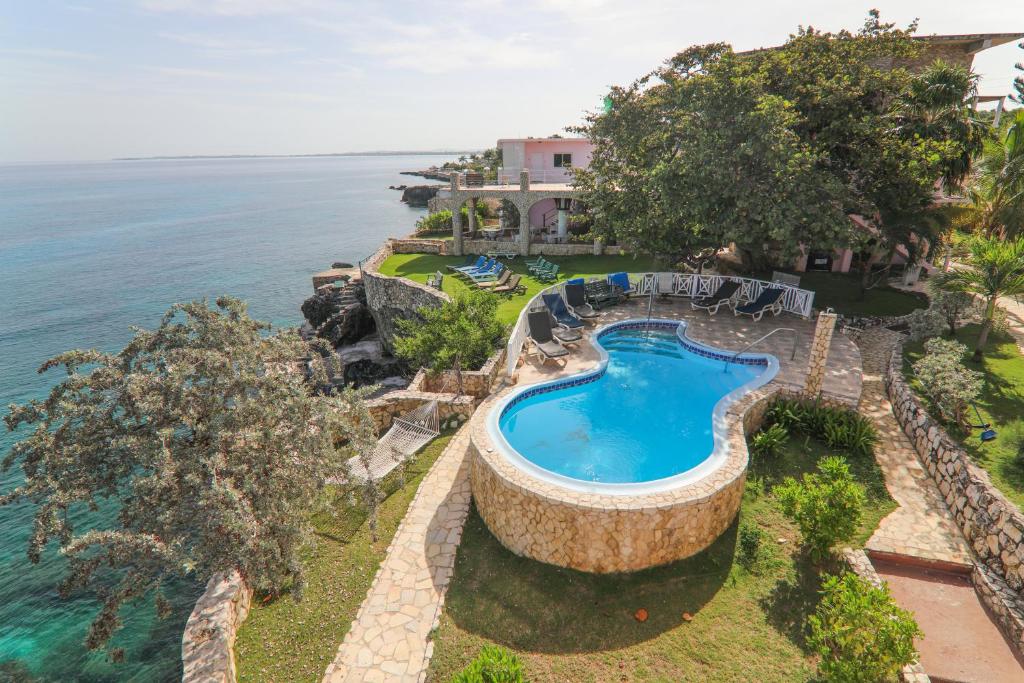an aerial view of a swimming pool next to the ocean at Home Sweet Home Resort in Negril